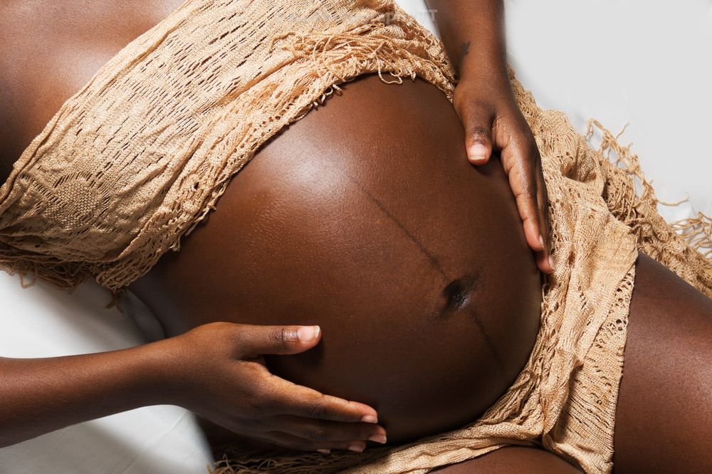Close-up maternity portrait with hands cradling the belly