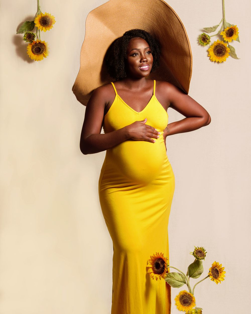 Expecting mother in a yellow gown styled with sunflowers