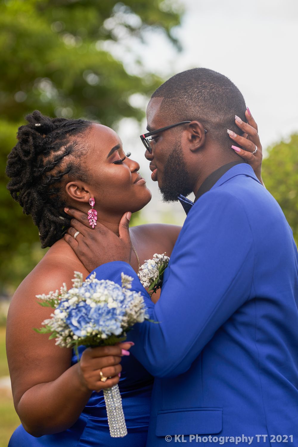 Bride and groom sharing a close moment in blue wedding attire