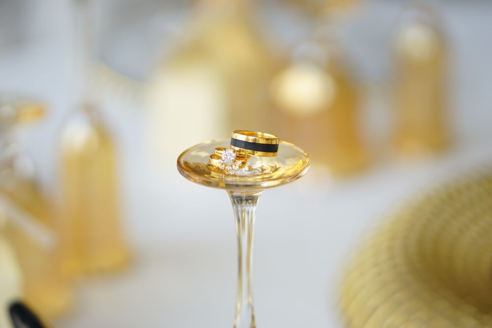 Wedding rings displayed on a gold-toned glass stand