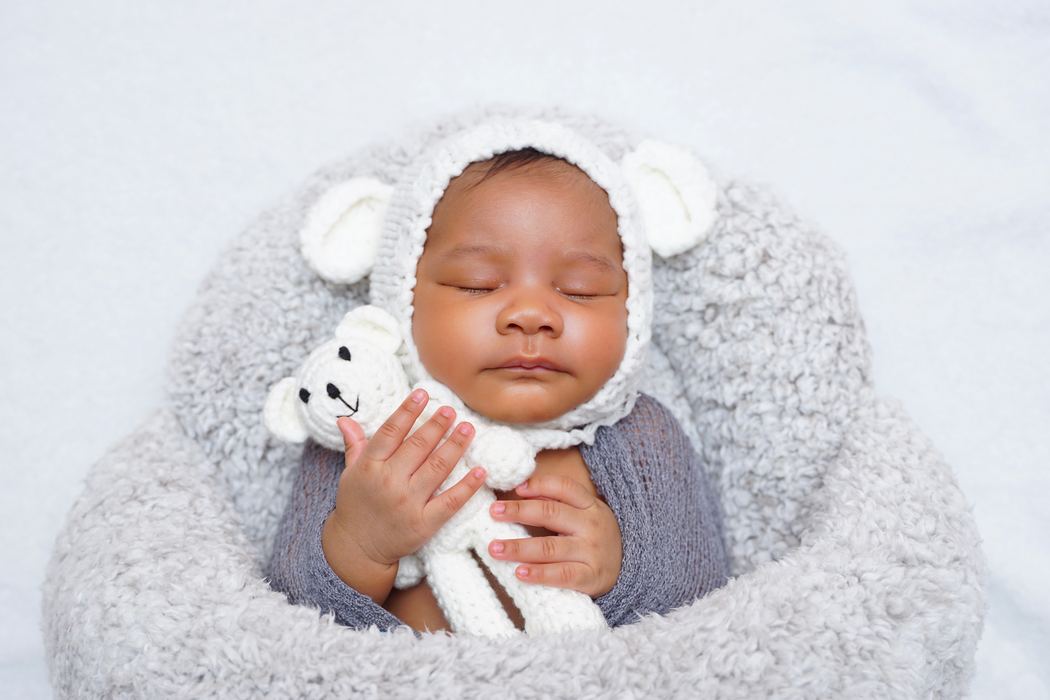 Sleeping newborn portrait in a knit bonnet